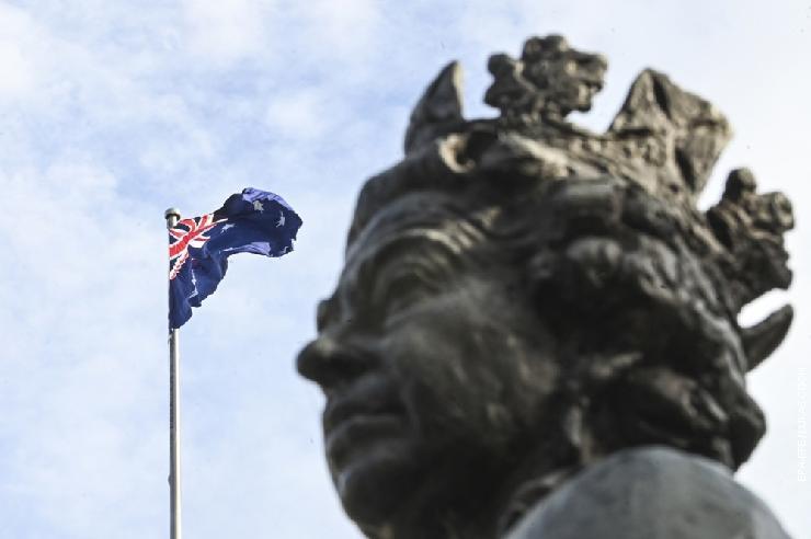 Аустралијска застава поред статуе краљице Елизабете II испред зграде парламента у Канбери, Аустралија